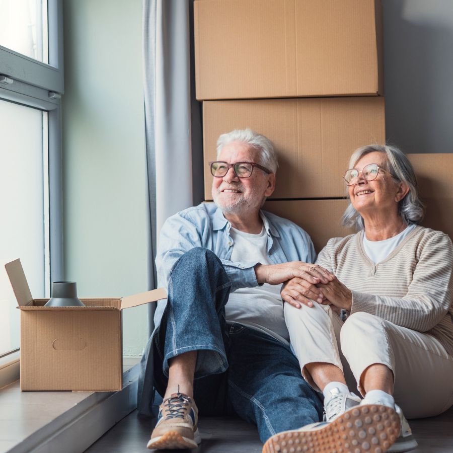 Elderly couple sitting by packed boxes